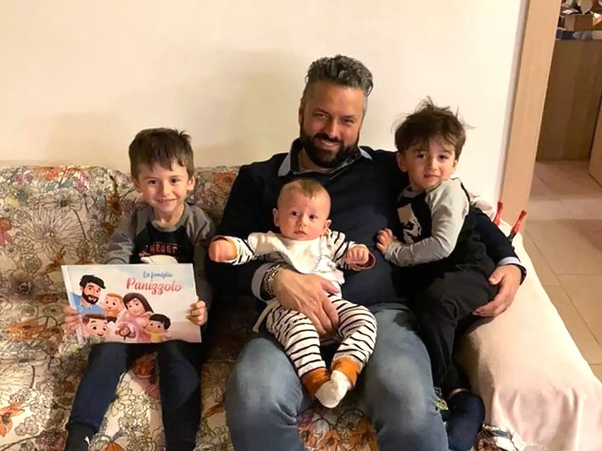 Un papà seduto sul divano e leggendo il libro di Urrà Eroi, un regalo perfetto per ogni occasione.