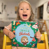 Una bimba tiene in mano un libro di Natale personalizzato, che è il miglior regalo per i bambini a Natale.