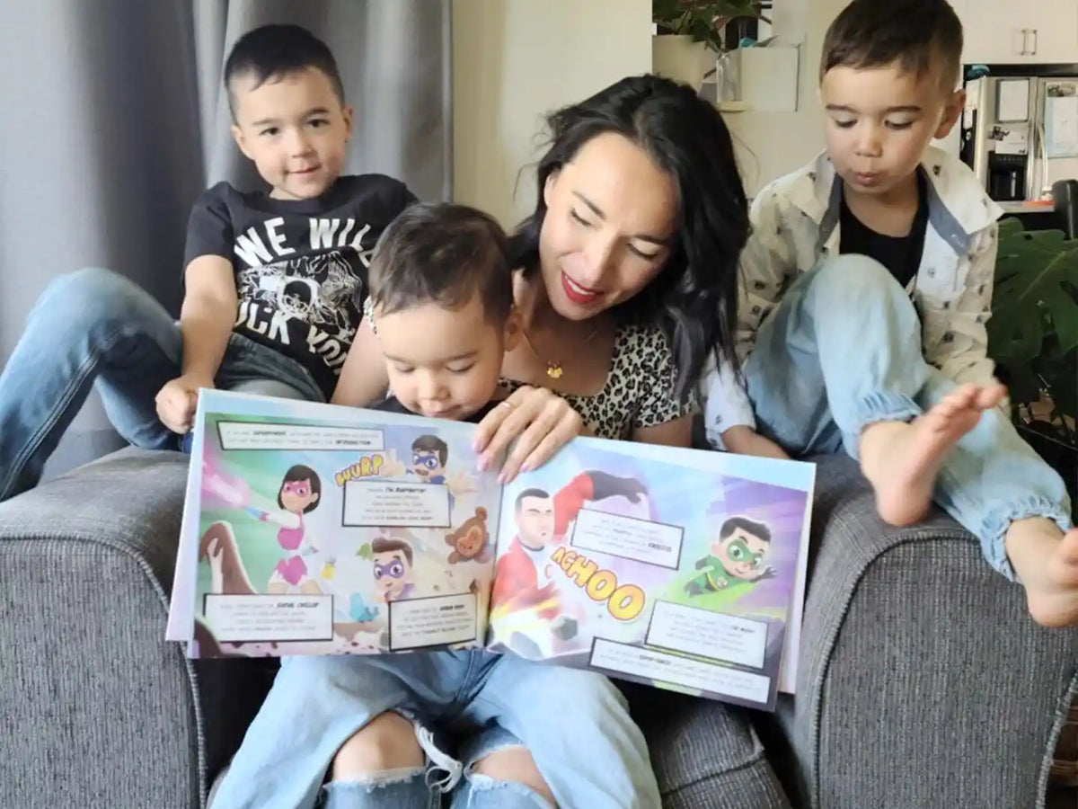 Una madre seduta sul divano con i suoi 3 figli che sfogliano il loro libro personalizzato per famiglie.