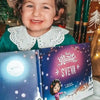 Una bambina mostra il suo regalo di Natale, un libro personalizzato di Urrà Eroi. 