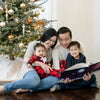 Una famiglia che festeggia il Natale con il regalo più carino di Urrà Eroi, il libro più personalizzato