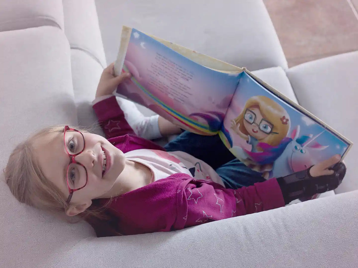 Ragazza che legge il suo bellissimo libro di compleanno personalizzato.