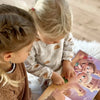 Due sorelle che leggono il loro libro personalizzato per i bambini.