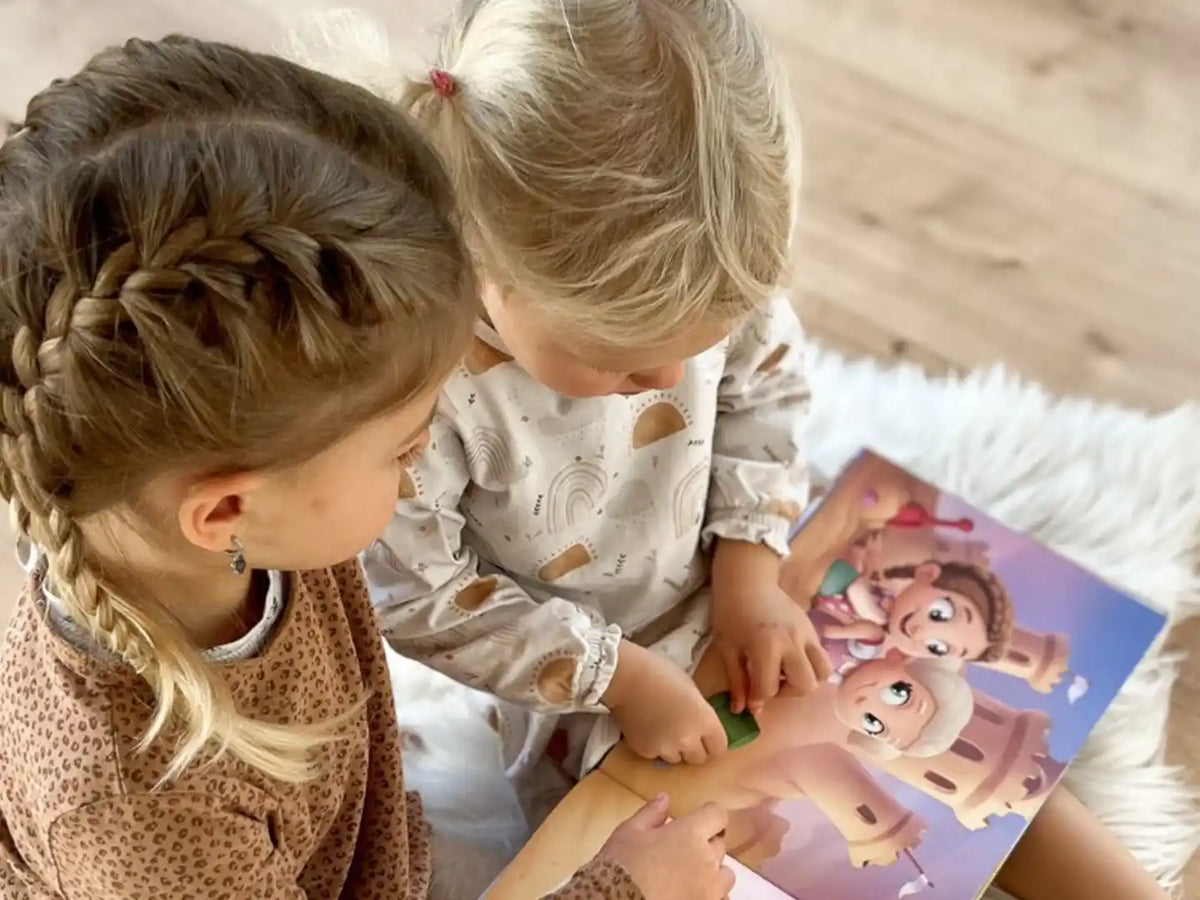 Due sorelle che leggono il loro libro personalizzato per i bambini.