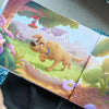 Pagina illustrata e colorata di un libro personalizzato per cani, con un cane disegnato felice che esplora un vivace giardino sul retro con fiori, una mangiatoia per uccelli e una staccionata bianca.