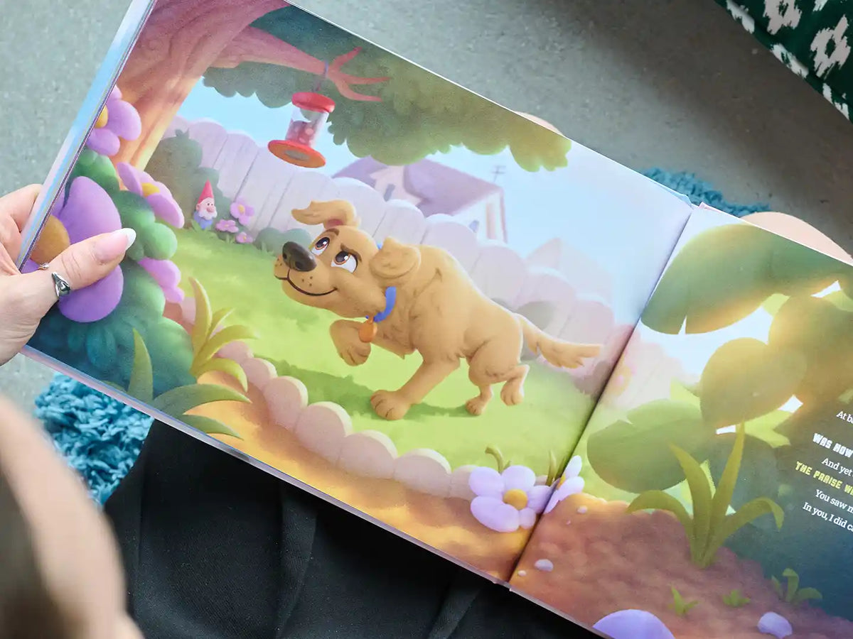 Pagina illustrata e colorata di un libro personalizzato per cani, con un cane disegnato felice che esplora un vivace giardino sul retro con fiori, una mangiatoia per uccelli e una staccionata bianca.