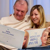 Papa e la sua figlia adulta leggono il libro que ha ricevuto per la festa de Papa.