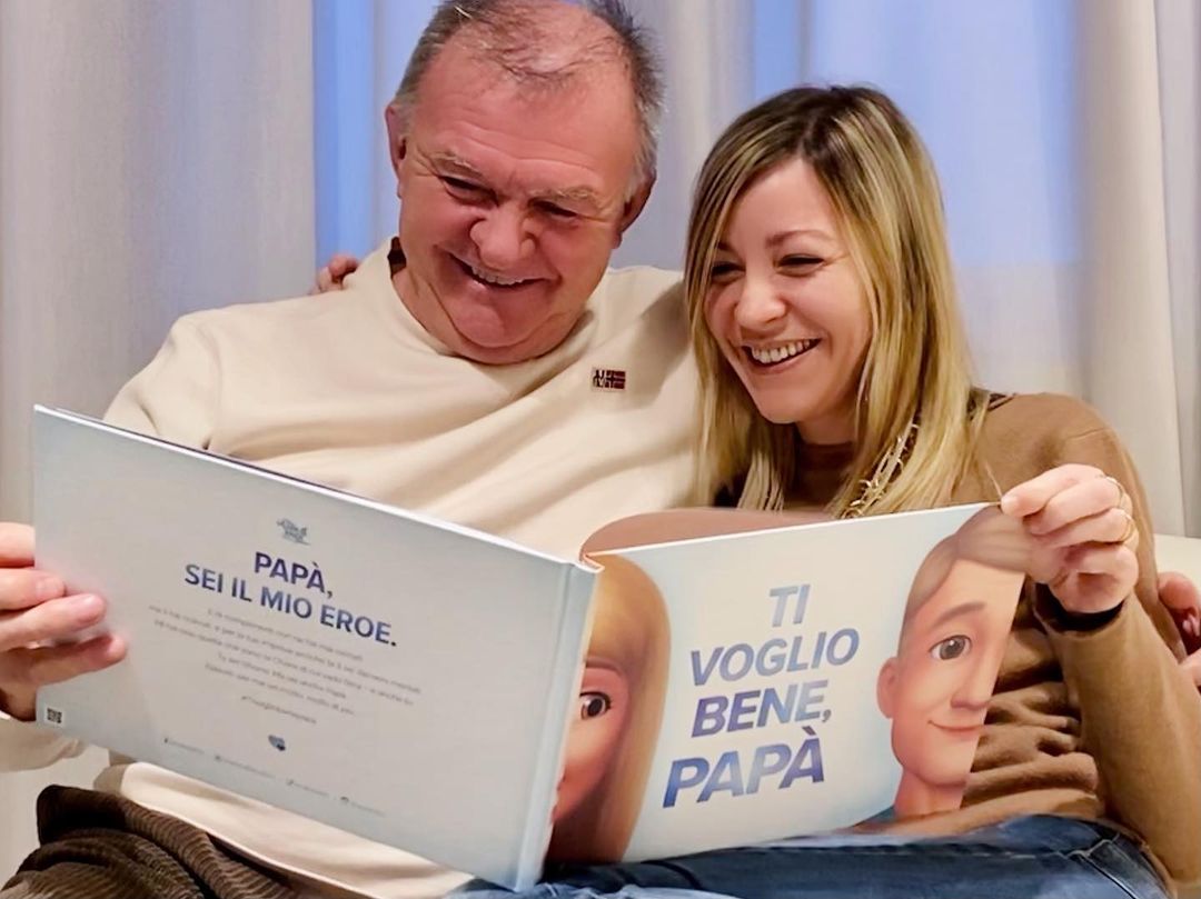 Papa e la sua figlia adulta leggono il libro que ha ricevuto per la festa de Papa.