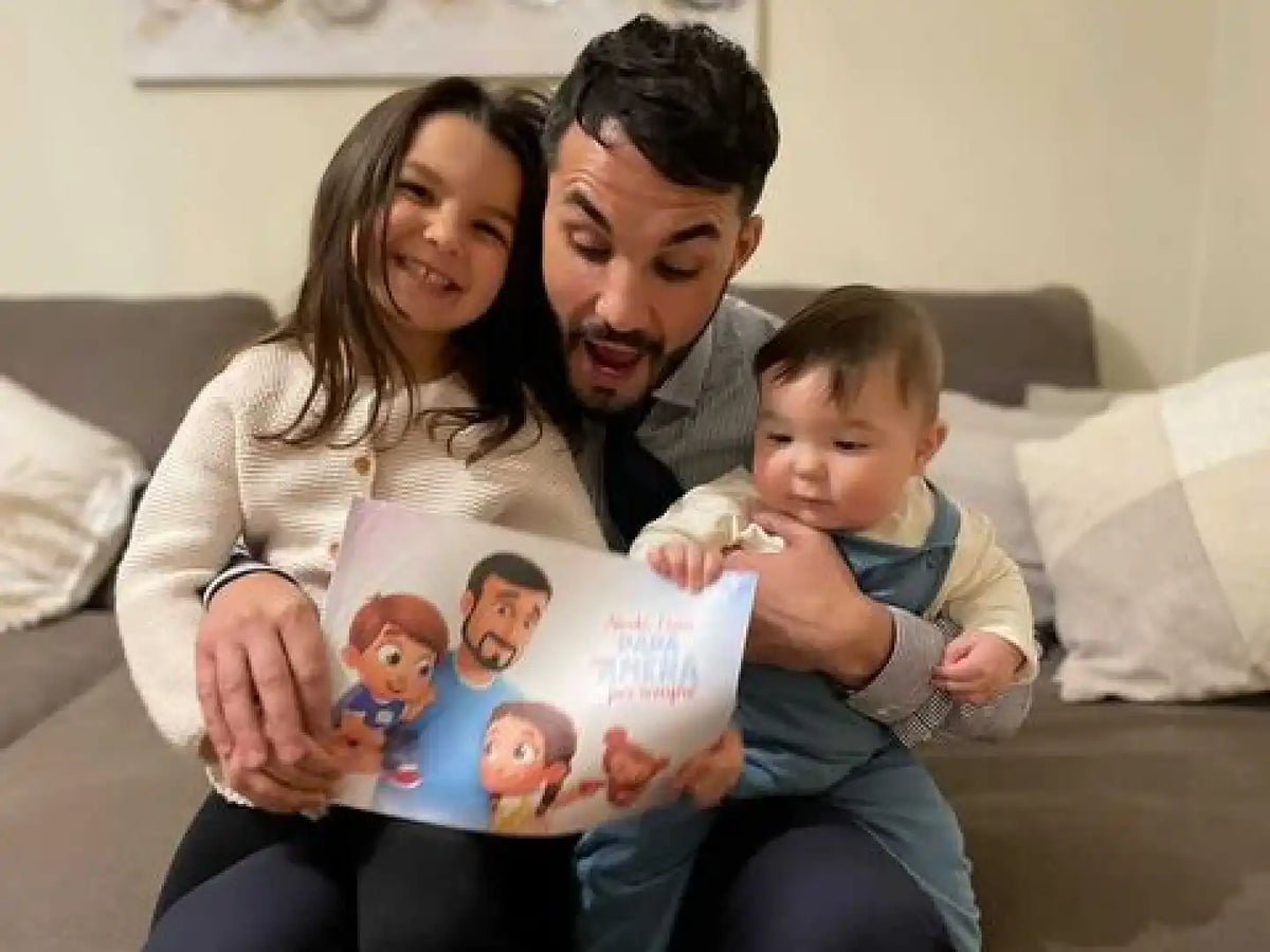 I papà e i loro due bambini stanno leggendo questo libro fai-da-te che hanno ricevuto come fantastico regalo per la Festa del Papà.