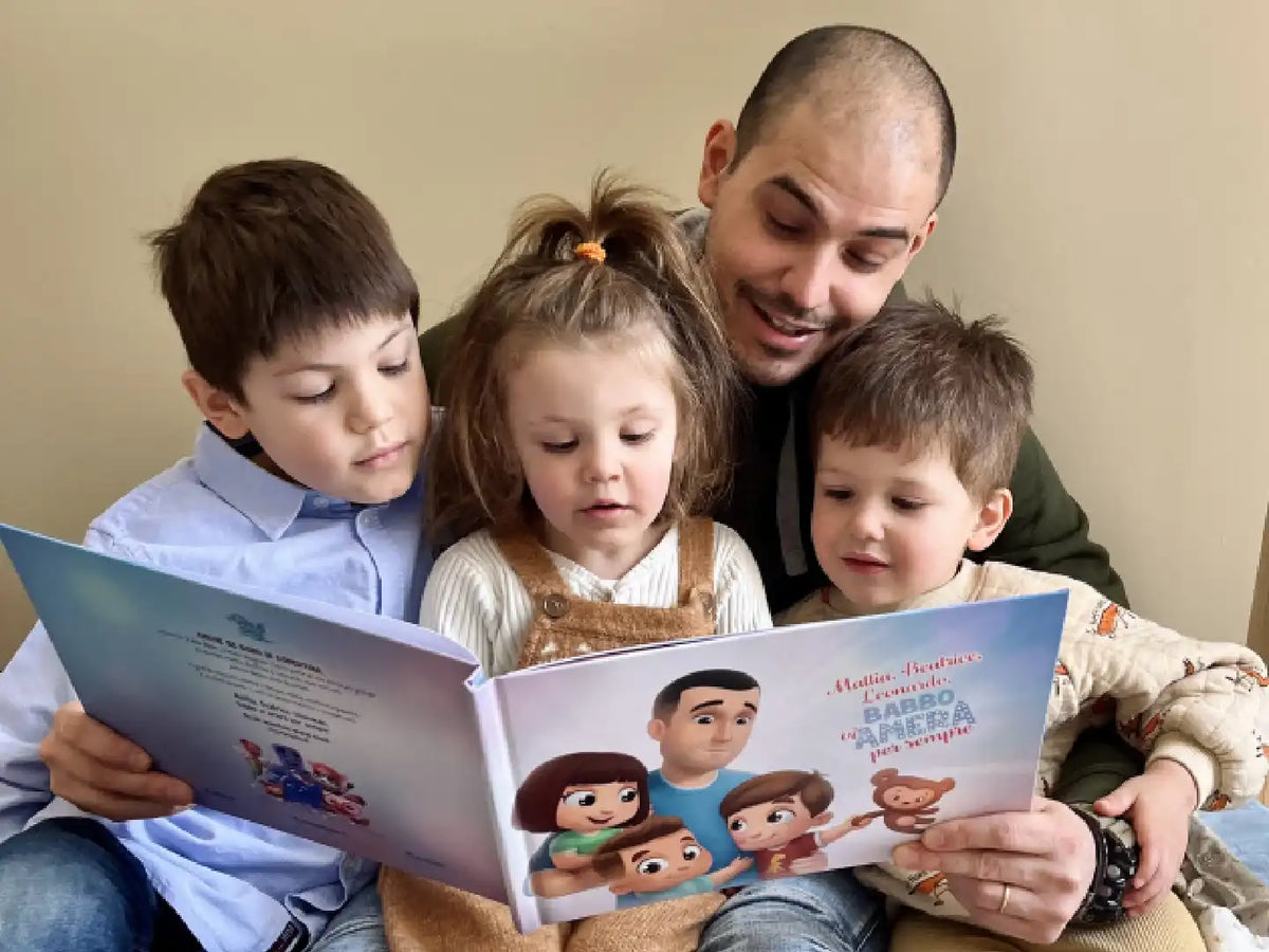 Papà tiene i suoi tre bambini tra le braccia e sta leggendo un libro personalizzato che include storie divertenti su di loro.
