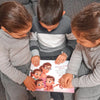 Mamme sorridenti e i loro bambini stanno godendo del loro libro personalizzato per più bambini.