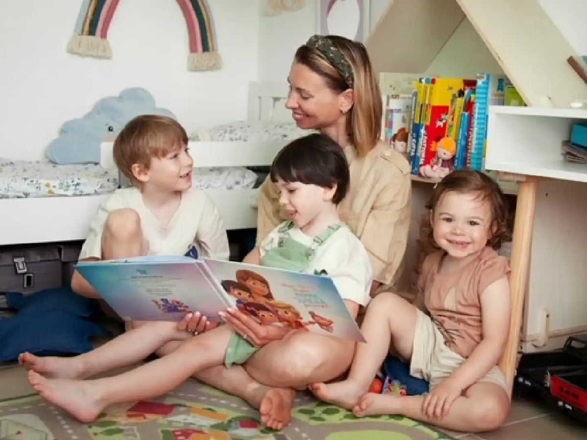 La mamma tiene tra le mani il suo prezioso regalo, un libro con personaggi personalizzati di lei e dei suoi tre bambini.
