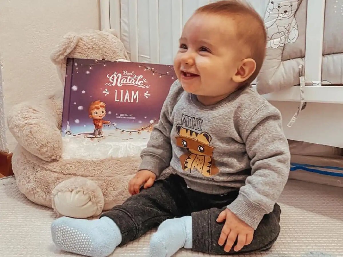 Un bambino che sorride con il simpaticissimo regalo di Urrà Eroi per Natale. 