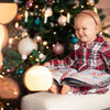 Una dolce bambina guarda il suo regalo di Natale personalizzato e pieno di divertimento