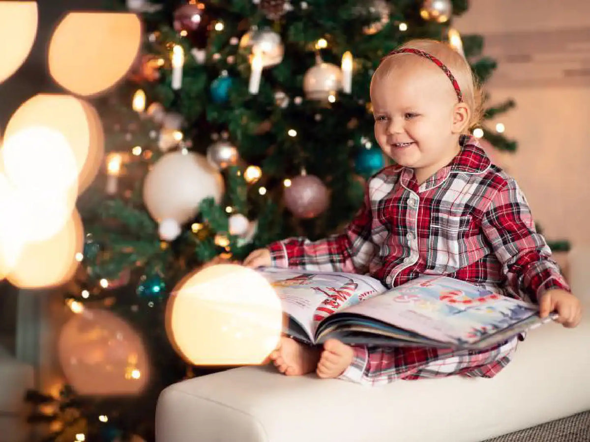 Una dolce bambina guarda il suo regalo di Natale personalizzato e pieno di divertimento