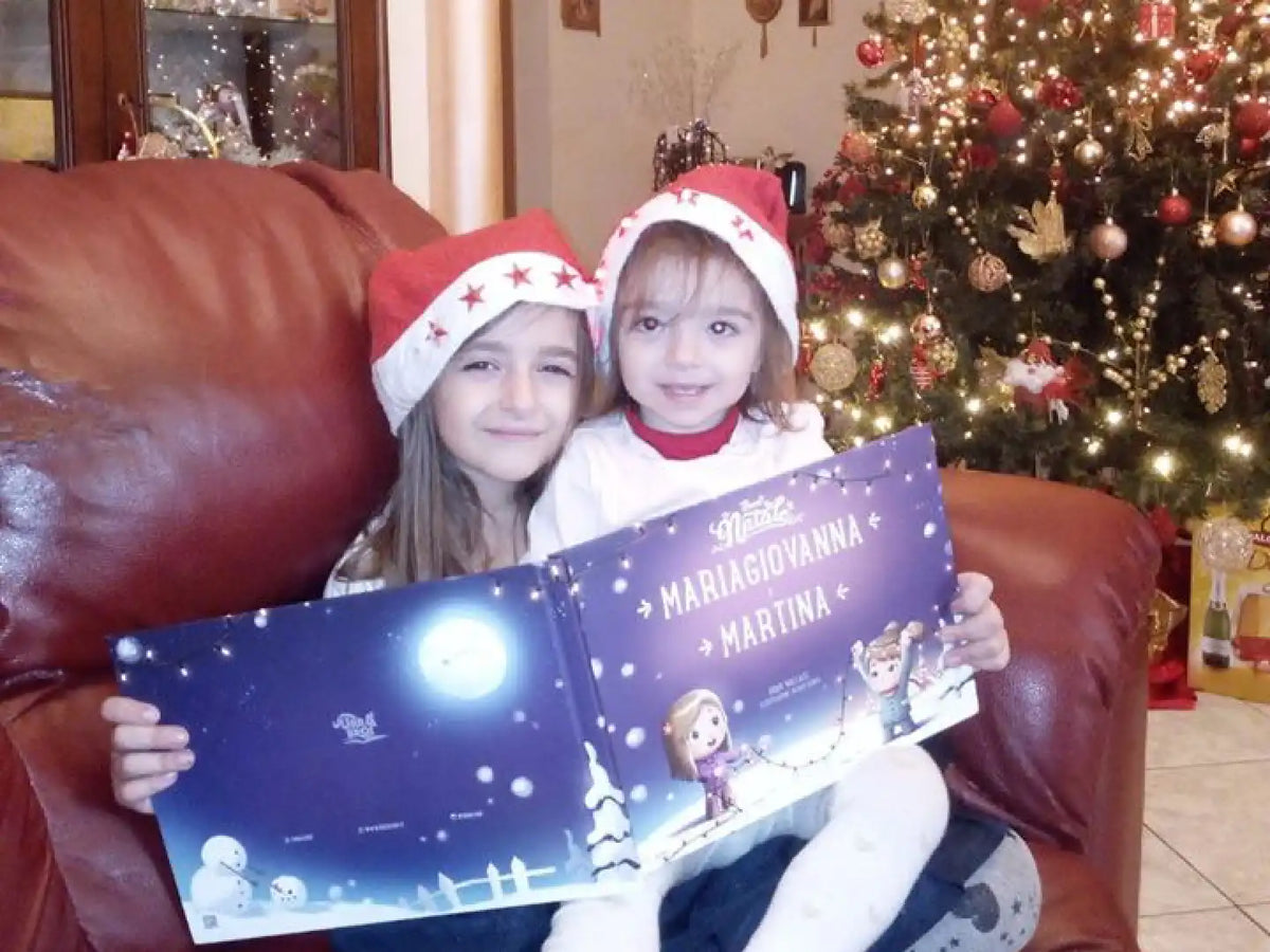 Due ragazze in poltrona e cappello natalizio felici del loro regalo personalizzato per Natale da Urrà Eroi