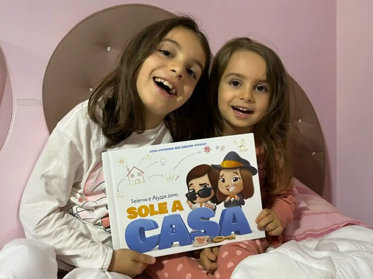 Due sorelle con il loro nuovo libro personalizzato sull'essere a casa da sole di Urrà Eroi.