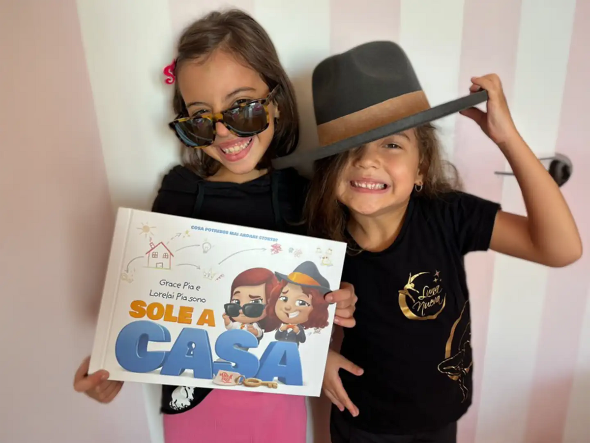 Due ragazze con in mano un libro personalizzato sullo stare a casa da sole.