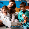Una mamma sta leggendo ai suoi figli un libro personalizzato per i fratelli.