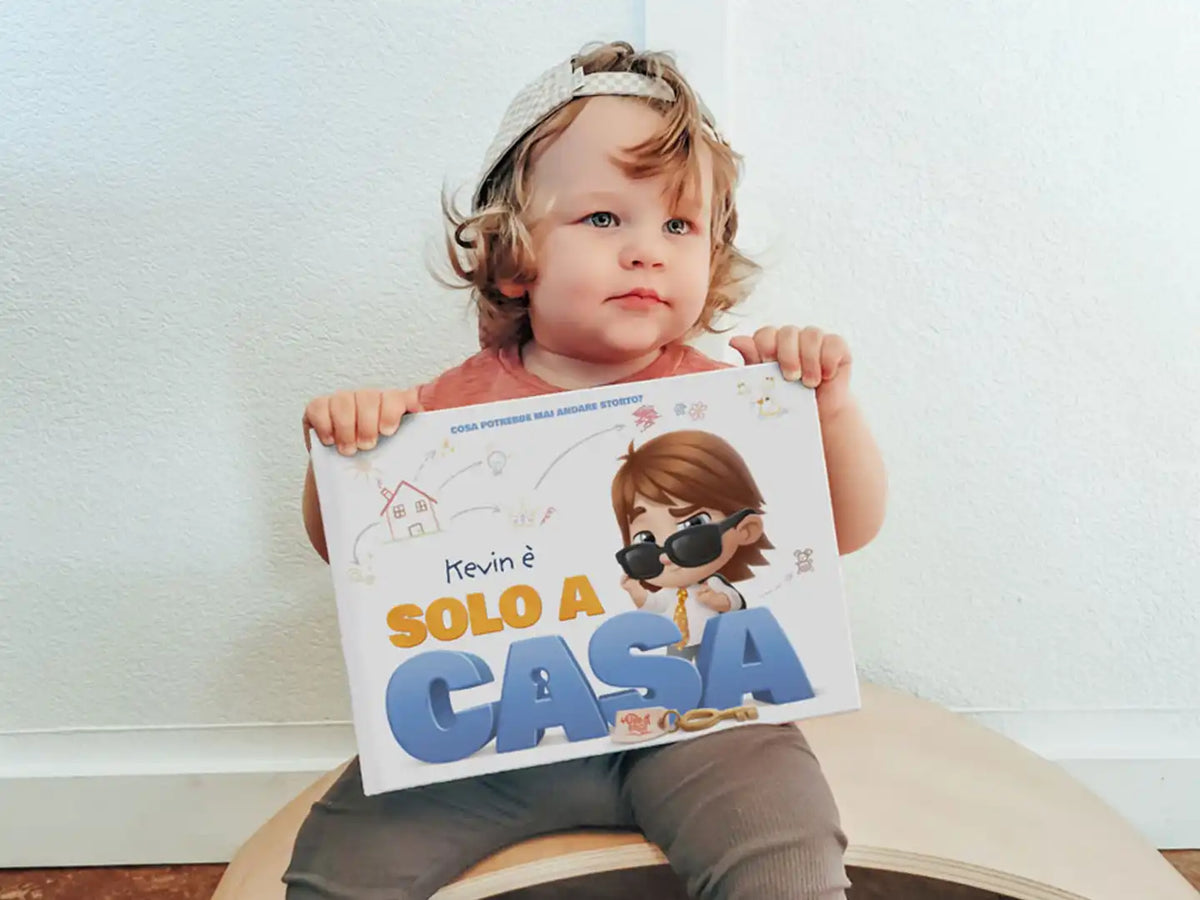 Kevin tiene in mano il suo libro personalizzato "Kevin è solo in casa" e si aspetta cose birichine.