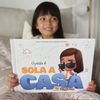 Una bambina con in mano il suo libro personalizzato sullo stare a casa da sola.