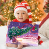 Bebè con cappello natalizio tiene il libro “Il nostro Primo Natale 2025” con Niccolò & Mami – perfetto regalo di Natale personalizzato.
