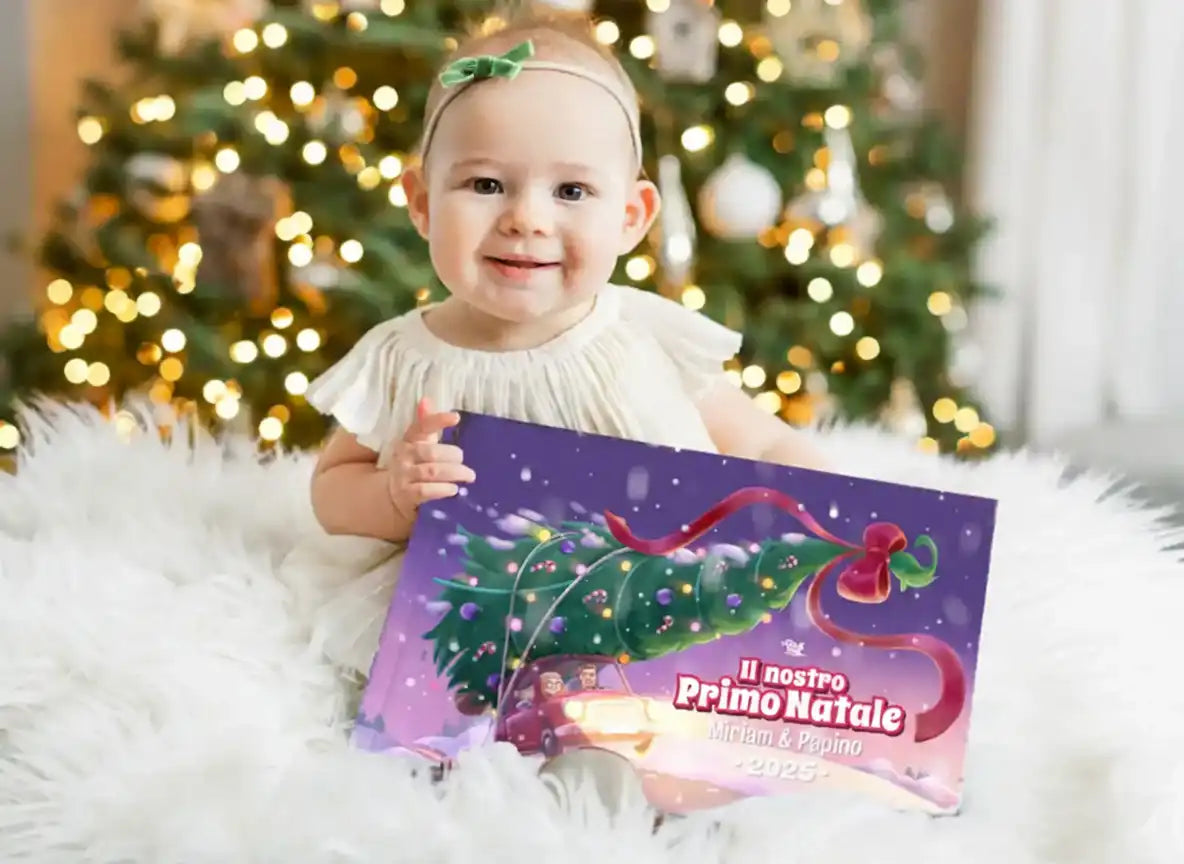 Bambina seduta tiene il libro personalizzato “Il nostro Primo Natale 2025” con Miriam & Papino, ideale come primo regalo natalizio.