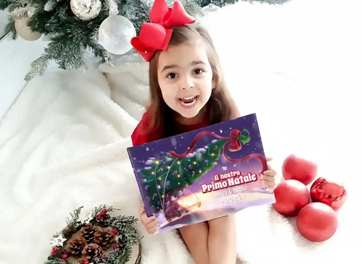 Bambina con fiocco rosso tiene il libro “Il nostro Primo Natale 2025” con Maya & Babbo, un dolce regalo di Natale per papà.