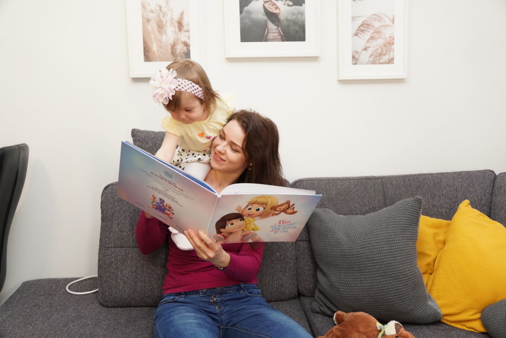 Una mamma e sua figlia felici di leggere il loro libro personalizzato di Urrà Eroi per le mamme.