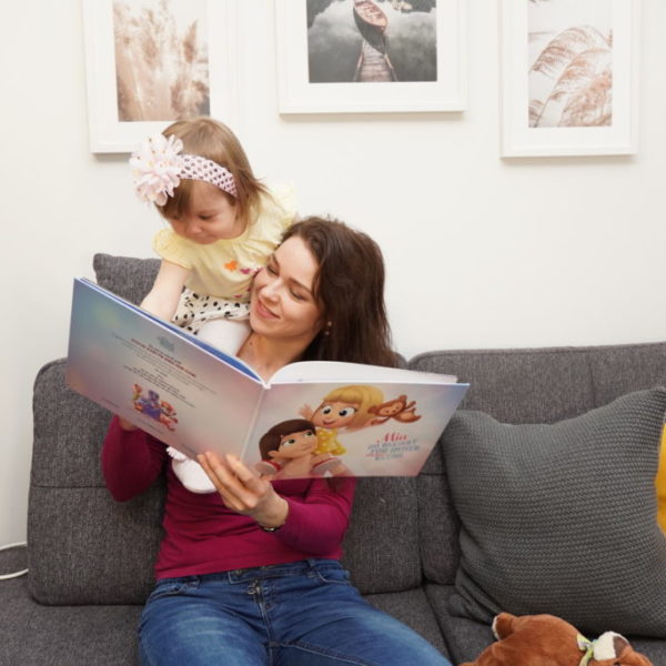 Una mamma e sua figlia felici di leggere il loro libro personalizzato di Urrà Eroi per le mamme.