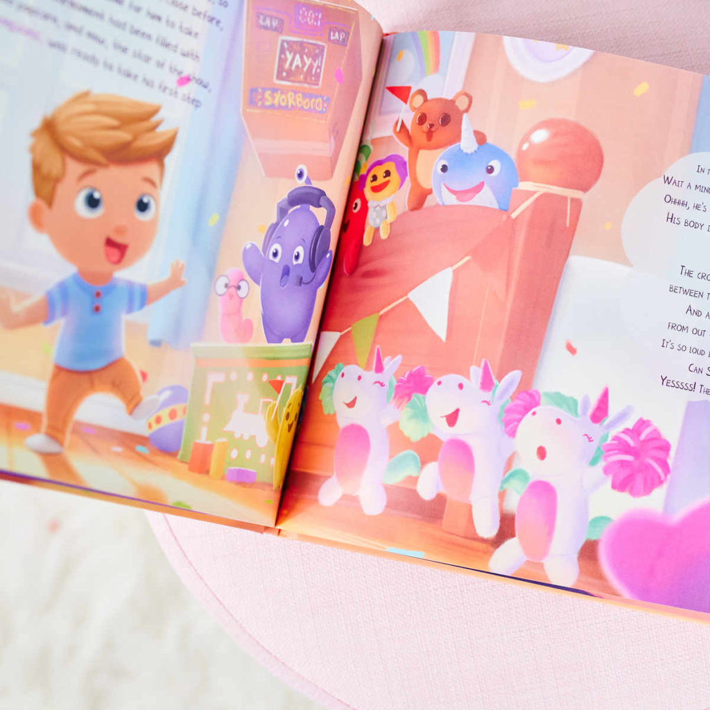 Il libro personalizzato aperto di Urrà Eroi sul letto, con le sue divertenti illustrazioni.