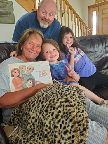 Nonni seduti su un divano con i nipoti che tengono in mano il loro libro personalizzato per i nonni.