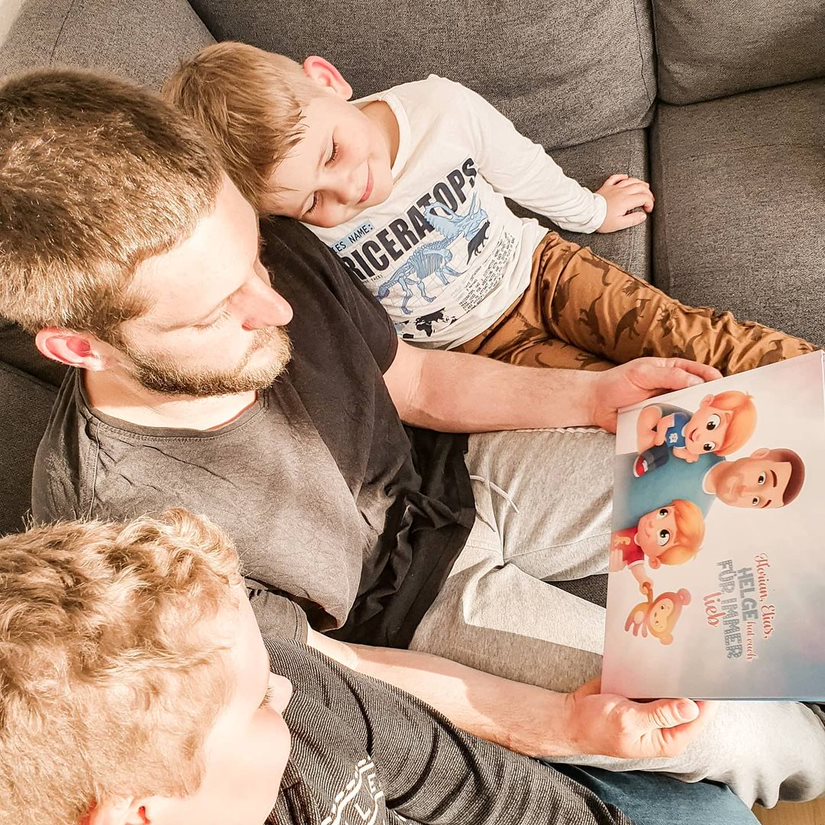 Un padre legge il libro personalizzato di Urrà Eroi con i suoi due figli sul divano.
