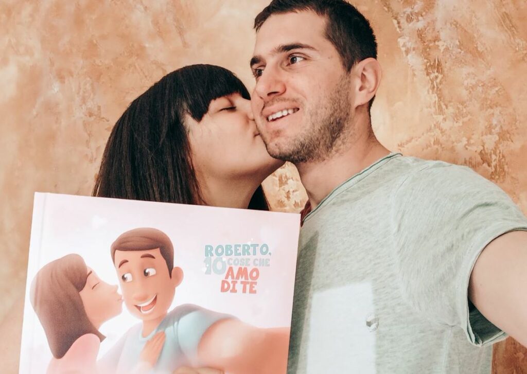 Una donna bacia un uomo sulla guancia mentre tiene in mano il libro personalizzato.