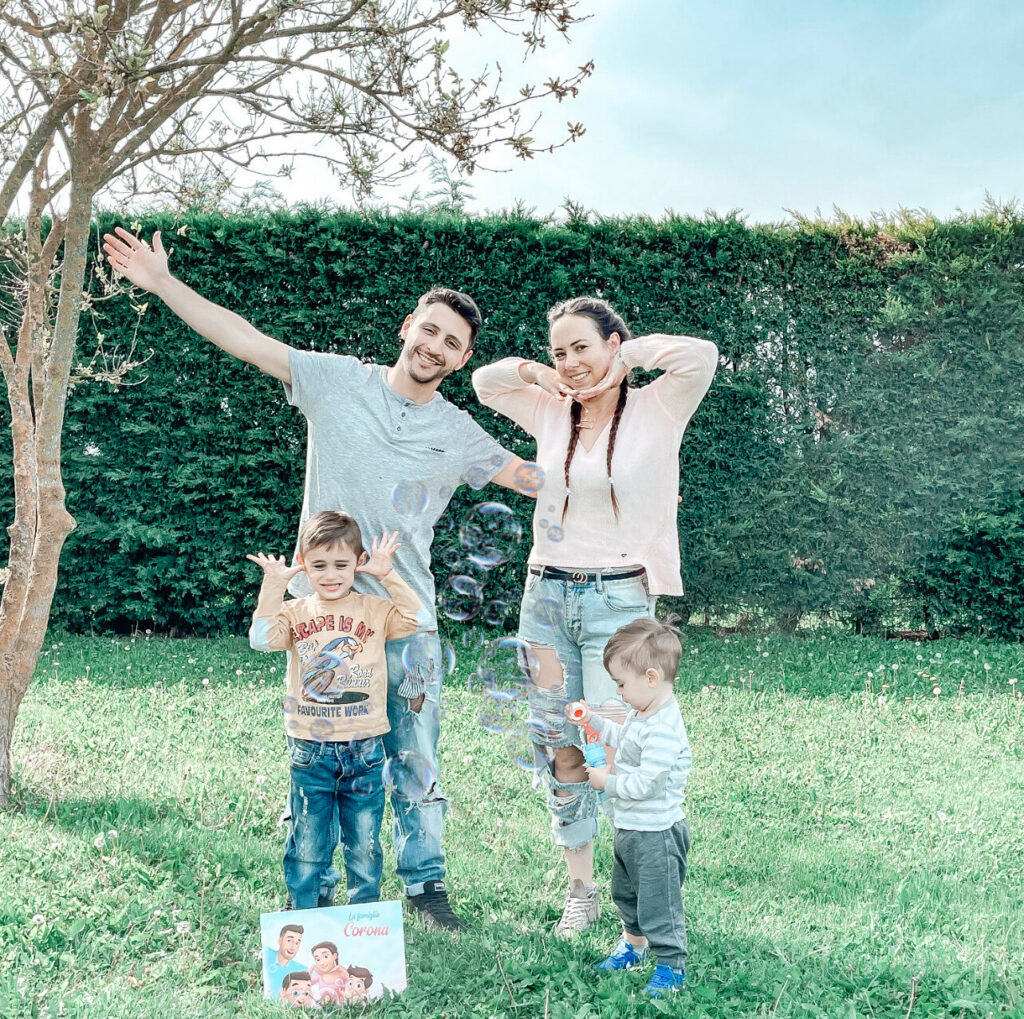 Una famiglia è in giardino con due bambini e il libro davanti.