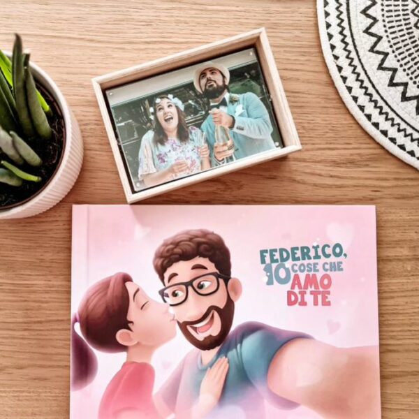 l'immagine mostra un libro personalizzato e una foto di coppia sul tavolo con un fiore in vaso.
