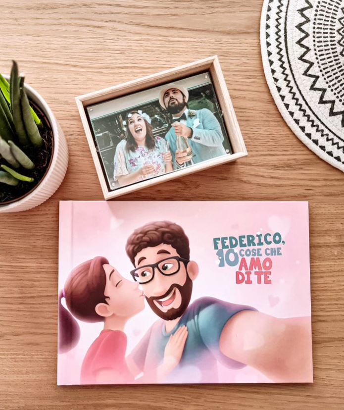 l'immagine mostra un libro personalizzato e una foto di coppia sul tavolo con un fiore in vaso.