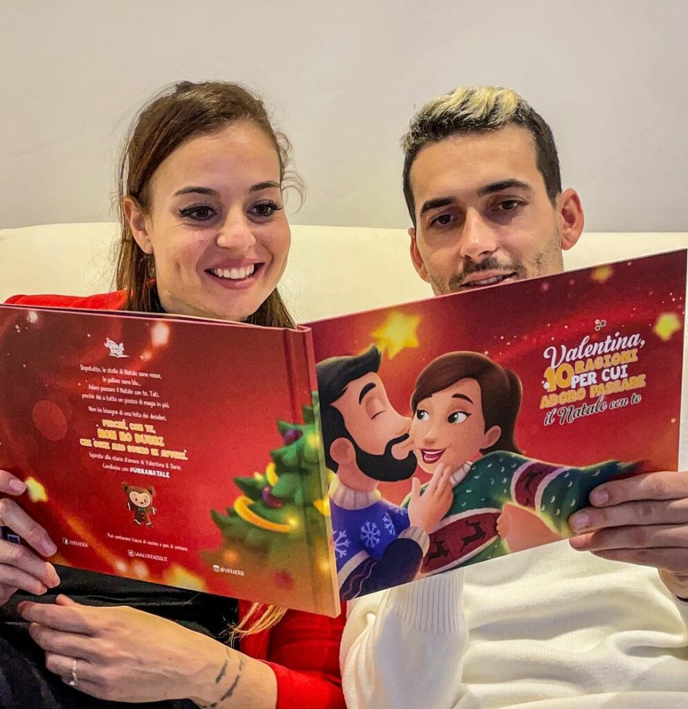 Una coppia seduta su un divano che legge il proprio libro personalizzato per le coppie per Natale