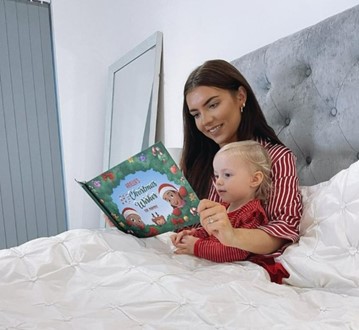 Mamma e bambino a letto che leggono una storia dai libri personalizzati di Urrà Eroi.