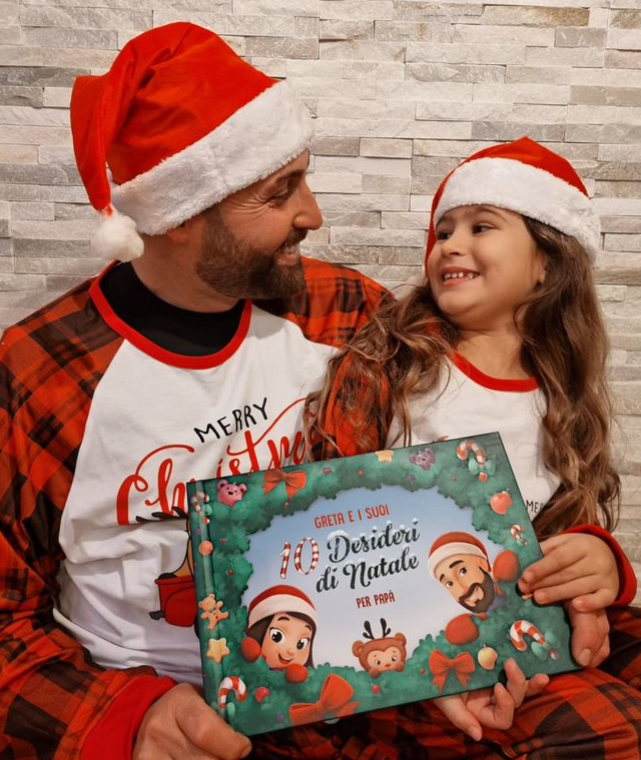 Un padre e una madre vestiti da Babbo Natale con in mano il loro libro personalizzato per Natale.