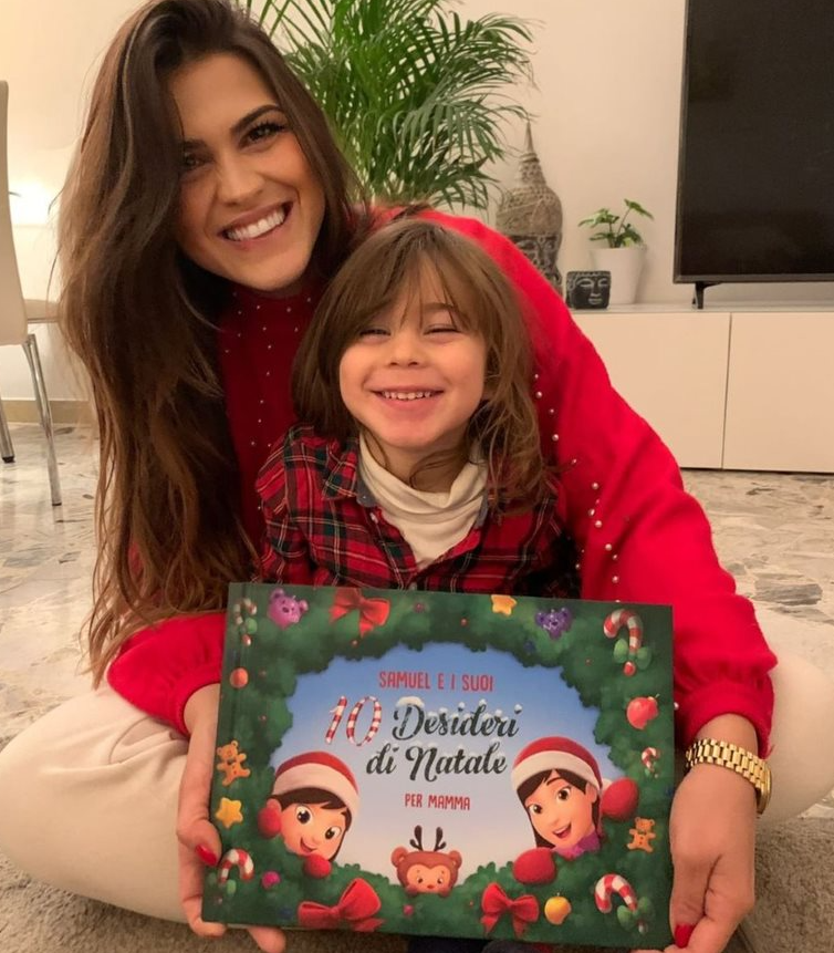 Una mamma e un bambino sorridono con il loro libro personalizzato per Natale.
