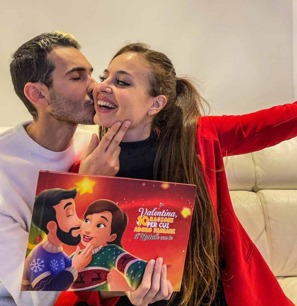 Una coppia con il suo libro personalizzato che si bacia 